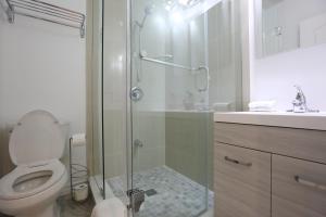 a bathroom with a toilet, sink, and shower at Elegant Suite at Bloor/Bathurst in Toronto