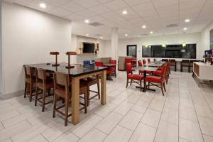 Holiday Inn Express & Suites Rancho Mirage - Palm Spgs Area, an IHG Hotel في رانشو ميراج: غرفة طعام مع طاولات وكراسي حمراء
