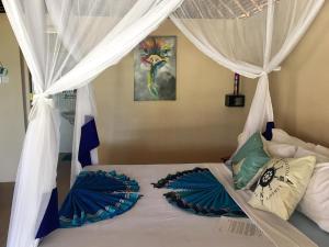 
a bed that has a blanket on top of it at Driftwood Beach Lodge in Jambiani
