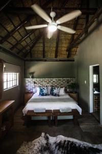 a bedroom with a bed and a ceiling fan at Breathe River Retreat in Parys