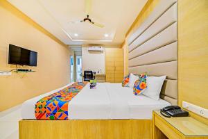 1 dormitorio con 1 cama grande y TV en FabHotel Viraj Suites Gachibowli, en Hyderabad