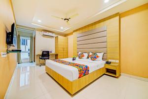 a hotel room with a bed and a desk at FabHotel Viraj Suites Gachibowli in Hyderabad