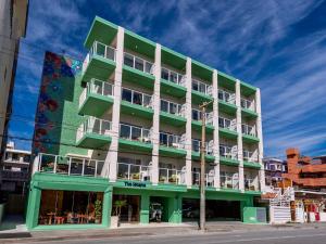 a green and white building on a street at The Moana by DSH Resorts in Chatan