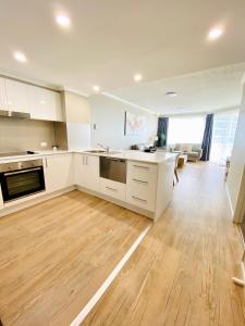 a kitchen with a stove top oven and a sink at Kirra Beach Apartments in Gold Coast