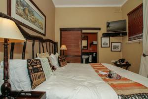 a bedroom with a large white bed in a room at Acorn B&B in Durban in Durban
