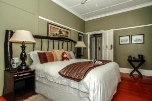 a bedroom with a large bed with a wooden headboard at Acorn B&B in Durban