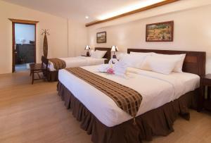 a hotel room with two large beds in it at Oasis Resort in Panglao