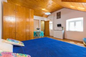 a bedroom with a large blue bed and wooden ceilings at Apartments Peppino - Old Town in Dubrovnik