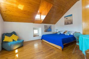 a bedroom with a blue bed and a couch at Apartments Peppino - Old Town in Dubrovnik