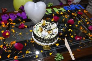 a birthday cake sitting on a table with flowers at TOURIST INN in Jaipur