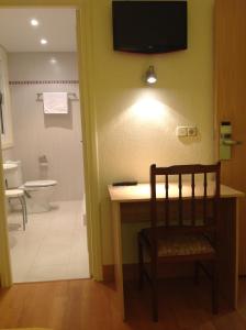 a bathroom with a desk and a toilet and a television at Pensión Lizaso in Irún