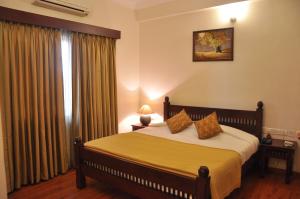 a bedroom with a bed and a window at Niketana @ Boat Club in Chennai