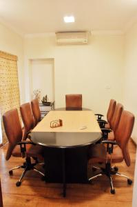 a conference room with a table and leather chairs at Niketana @ Boat Club in Chennai