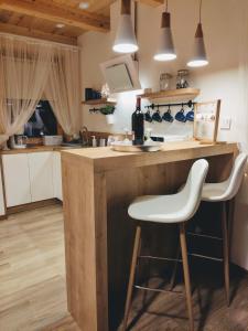 a kitchen with a counter and a bar with a white stool at Apartament Borowikowe Zacisze in Falsztyn +36 photos