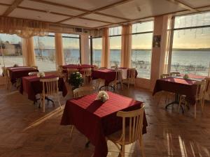 ミチュリンスコエにあるSpa Hotel Michur Innの水辺の景色を望むテーブルと椅子付きのレストラン
