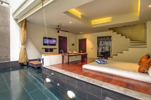 a living room with a couch and a staircase at 18 Suite Villa Loft at Kuta in Kuta