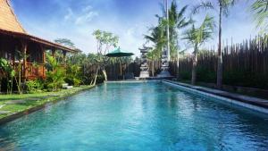 una piscina de agua azul en un complejo en Galang hari villa, en Ubud
