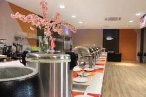 a row of tables with plates and flowers in a restaurant at Desa Selatan Resort Pengerang in Pengerang