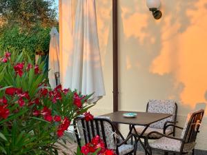 a table and chairs and a white umbrella and flowers at Villino Eleonora in Parghelia