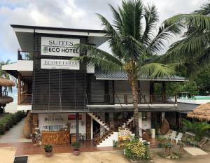 a hotel with a palm tree in front of it at Suites by Eco Hotel El Nido in El Nido