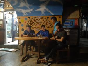 un grupo de hombres sentados en una mesa en un restaurante en Beach Guest House, en Maninjau