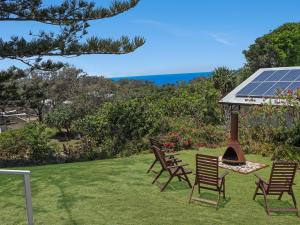 a group of chairs sitting in the grass with a solarium at Ahoy Cottage in Point Lookout