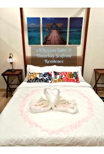 - un lit avec 2 chaussons blancs dans l'établissement Timurbay Seafront Residence aRRayyan Suites, à Kuantan