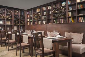 a dining room with tables and chairs and bookshelves at Royal Park Apartments in Bansko