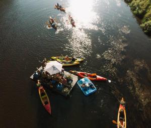 un grupo de personas en barcos en el agua en Camping Jaunzāģeri, en Inciems