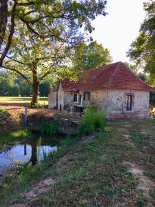 una vecchia casa seduta sul fianco di un fiume di Le Moulin de Lassalle a Curemonte