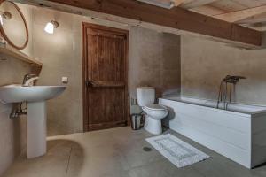 a bathroom with a sink and a tub and a toilet at Mastrogiannis Farm House in Armenádes