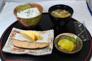 um prato de comida com peixe e uma tigela de sopa em Hotel Sindbad Hirosaki-Adult Only em Hirosaki