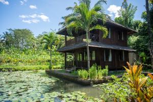 
a house with trees and a boat in the water at Villa Uma Ayu Sidemen in Sidemen
