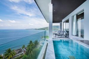 Cape Sienna Phuket Gourmet Hotel & Villas - SHA Extra Plus في شاطئ كامالا: اطلالة على المحيط من منزل به مسبح