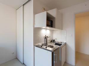 a small kitchen with a sink and a refrigerator at Duplex coquet avec PARKING proche centre-ville de Lyon in Villeurbanne