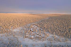 an aerial view of a snowy field with a river at Wilderness Hotel Muotka & Igloos in Saariselka