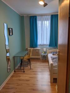 a small room with a bed and a desk and a table at Ruhrtropolis Hostel in Essen