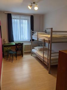 a room with two bunk beds and a desk at Ruhrtropolis Hostel in Essen