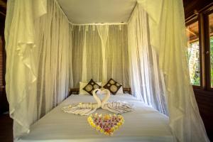 
a bed with a canopy on top of it at Villa Uma Ayu Sidemen in Sidemen
