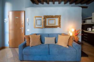 a blue couch with pillows in a living room at Appartamenti Venezia in Venice