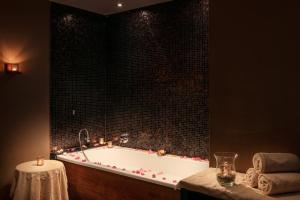 a bathroom with a bath tub with candles in it at Hotel KINGS COURT in Prague