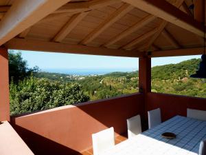 a table and chairs on a balcony with a view at Mastrogiannis Farm House in Armenádes
