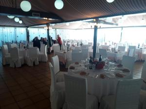 ソト・レアルにあるGran Hostal Asador de Sotoの白いテーブルと白い椅子が備わる宴会場