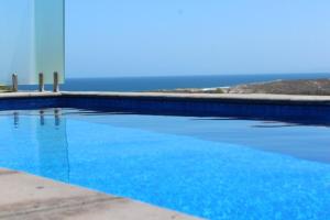 a blue swimming pool with the ocean in the background at Eco Haven retreat in Kalbarri