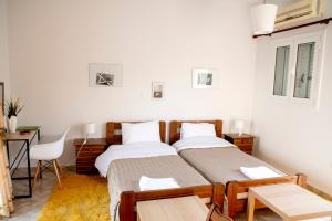 two beds in a room with a table and a desk at Paleo Kalamaki in Isthmia