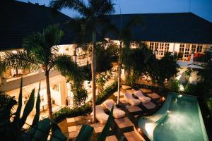 Una vista aérea de un hotel con piscina y palmeras. en Casa Artista By Kresna Hospitality, en Seminyak