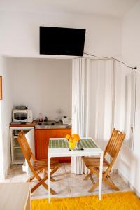 a kitchen with a white table and two chairs at Paleo Kalamaki in Isthmia