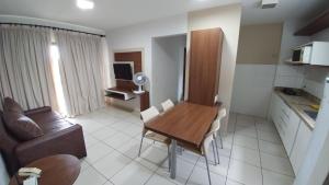 a kitchen and dining room with a table and a couch at Apartamento Caldas Novas in Caldas Novas