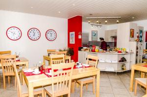 een restaurant met tafels en klokken aan de muur bij Meike's Guesthouse in Swakopmund