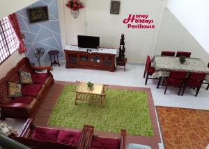 a living room with a couch and a table at Honey Holiday Penthouse in Tanah Rata